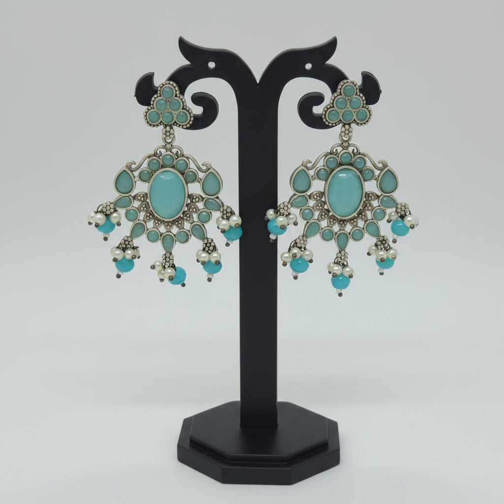Antique oxidised silver dangler earrings with a floral motif and cool mint Monalisa stonework, accompanied by cool mint bead dangles and semi-precious stones .