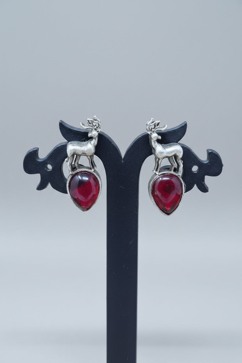premium oxidised stud earrings featuring silver deer motifs on top of red teardrop-shaped semi-precious