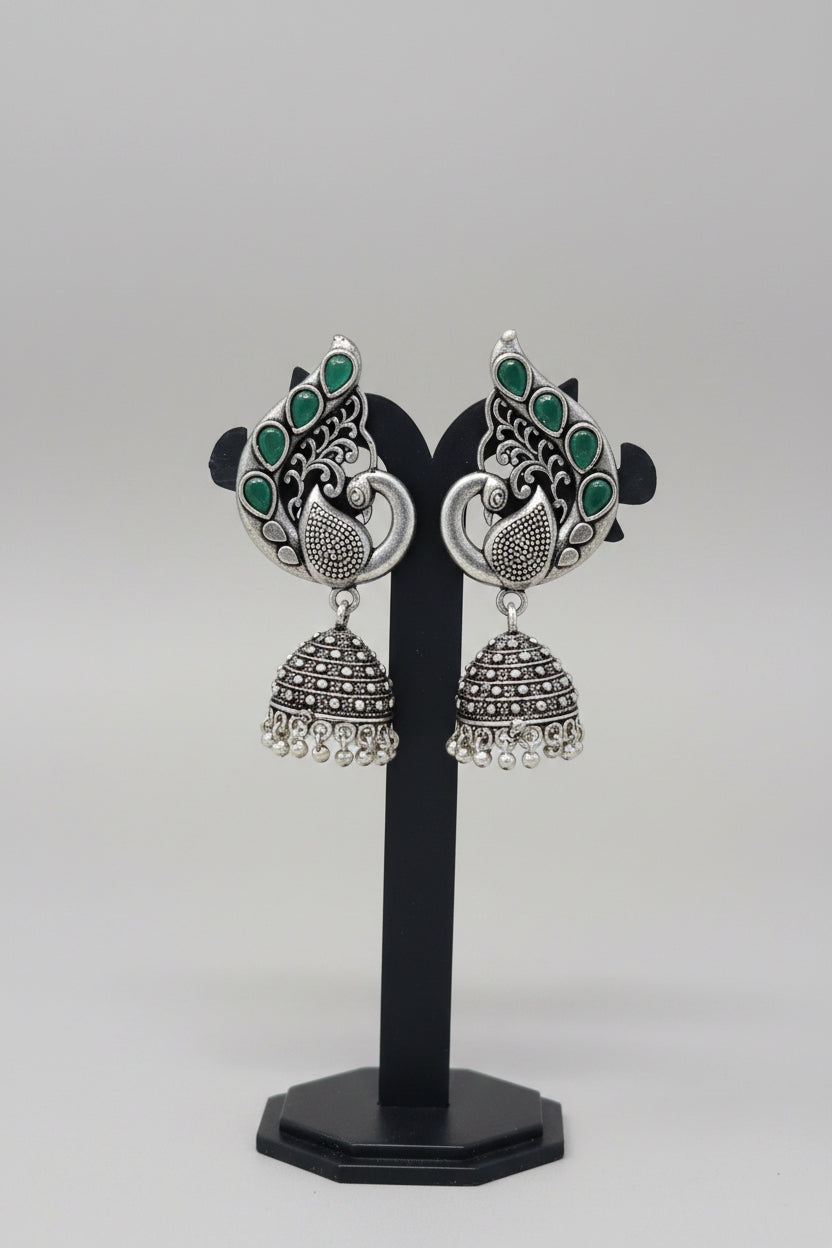 Pair of oxidised silver jhumka earrings, peacock motif with green gemstones.