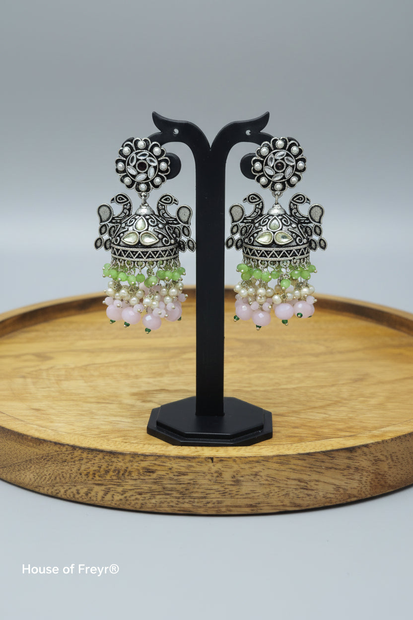 A pair of oxidized silver jhumka earrings with intricate Pachi Kundan work and green color beaded
