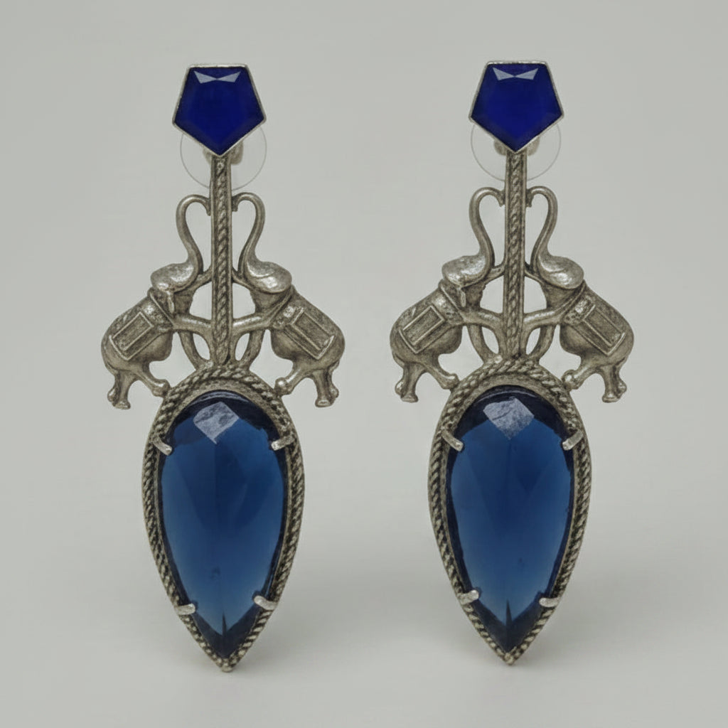 Pair of  stylish indo-western oxidised dangler earrings with bid blue stone, blue tops, and elephant motif.