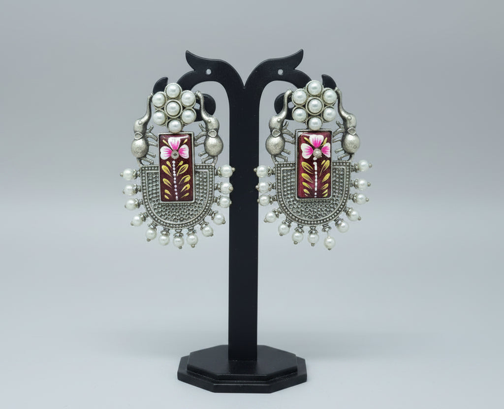 Pair of oxidised dangler with handmade Meenakari work on red moissanite stone, with pearls and elephant motif