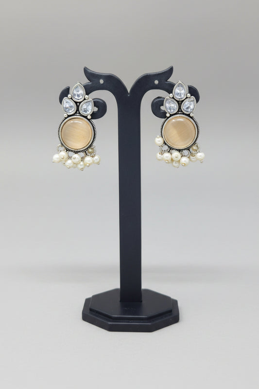 Premium oxidised Chandbali-style earrings with white onyx stones, surrounded by crystal accents, and pearl dangles.