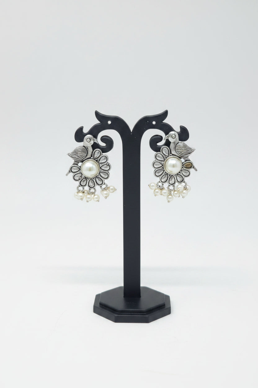 A pair of oxidised silver bird motif earrings with a floral patter with pearls