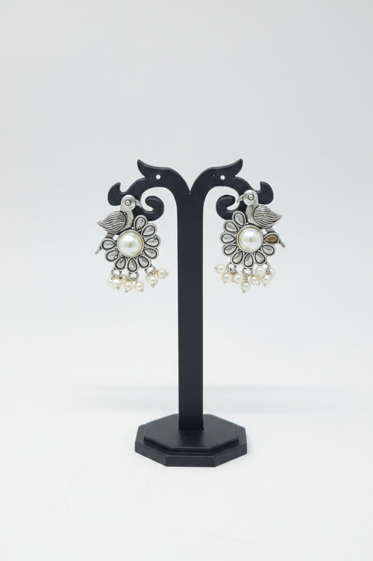 A pair of oxidised silver bird motif earrings with a floral patter with pearls