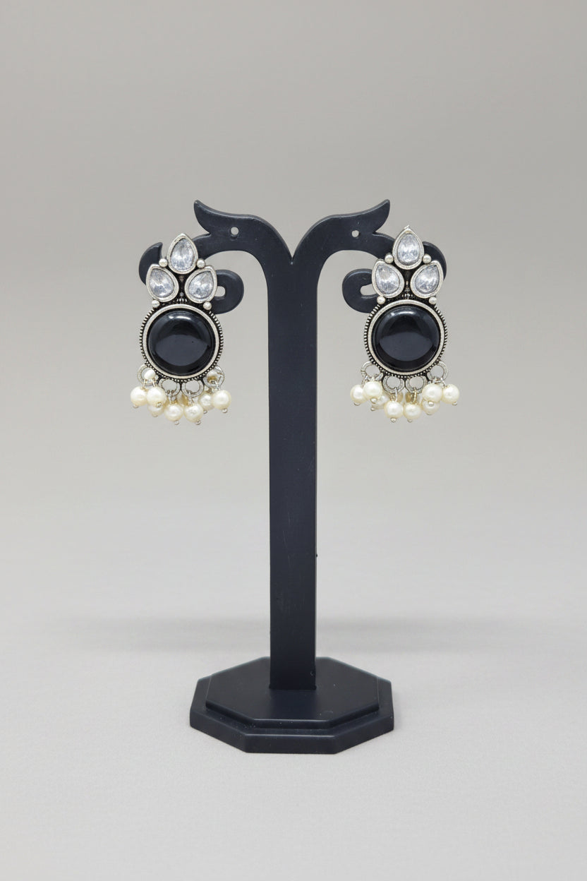 Premium oxidised Chandbali-style earrings with black onyx stones, surrounded by crystal accents, and pearl dangles.