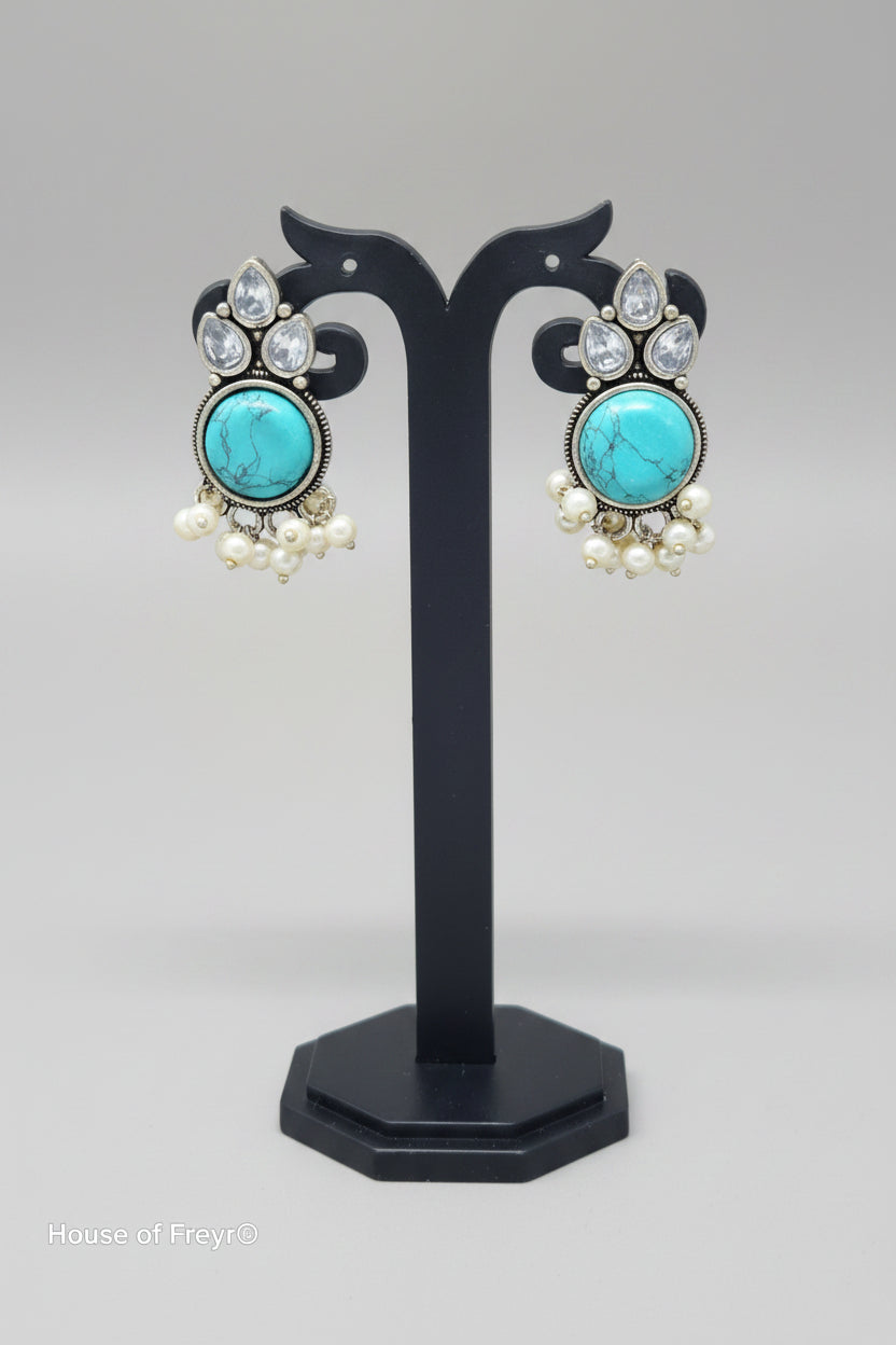 Premium oxidised Chandbali-style earrings with turquoise onyx stones, surrounded by crystal accents, and pearl dangles.