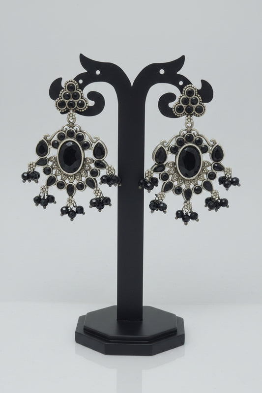 Antique oxidised silver dangler earrings with a floral motif and black Monalisa stonework, accompanied by black bead dangles and semi-precious stones .