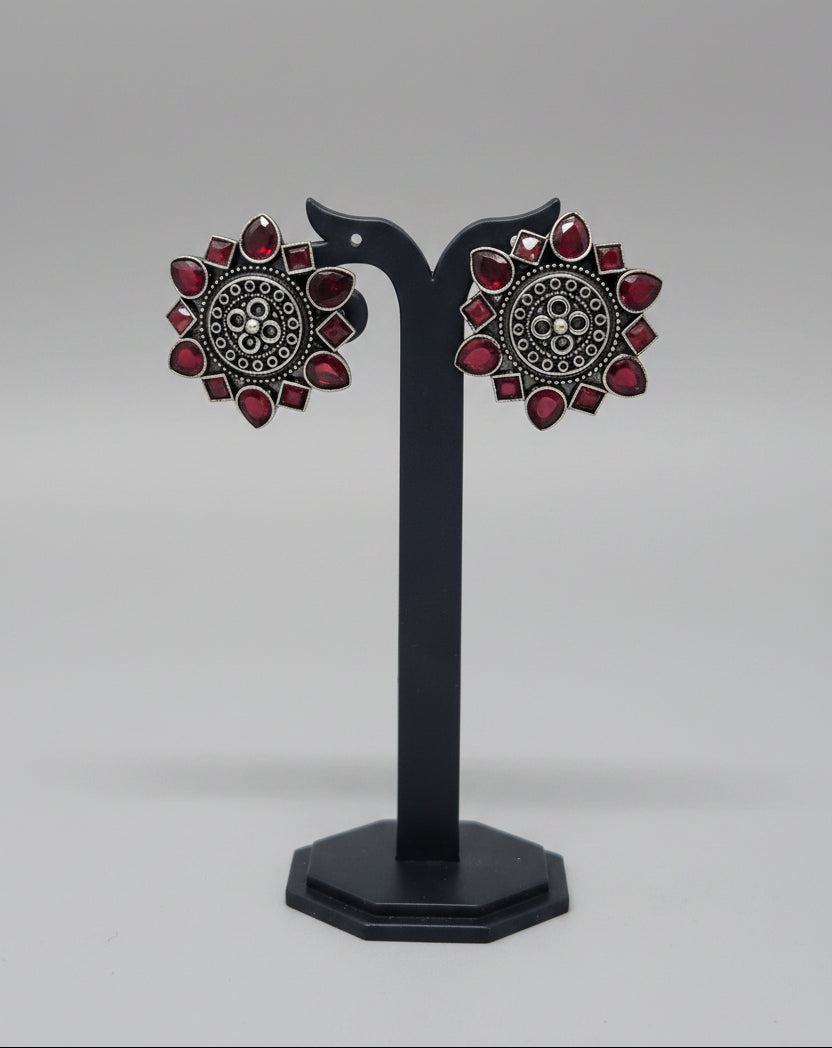 Pair of oxidised floral stud earrings with red gemstone