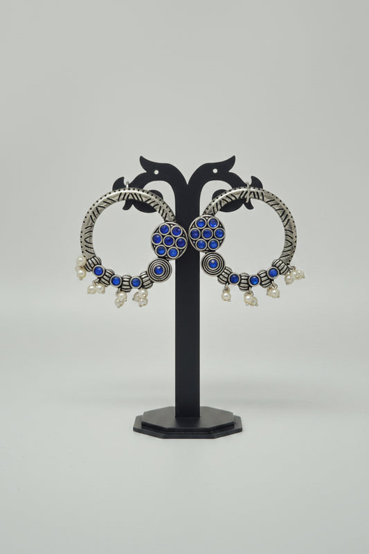 Pair of oxidised hoop earrings with blue gemstones.
