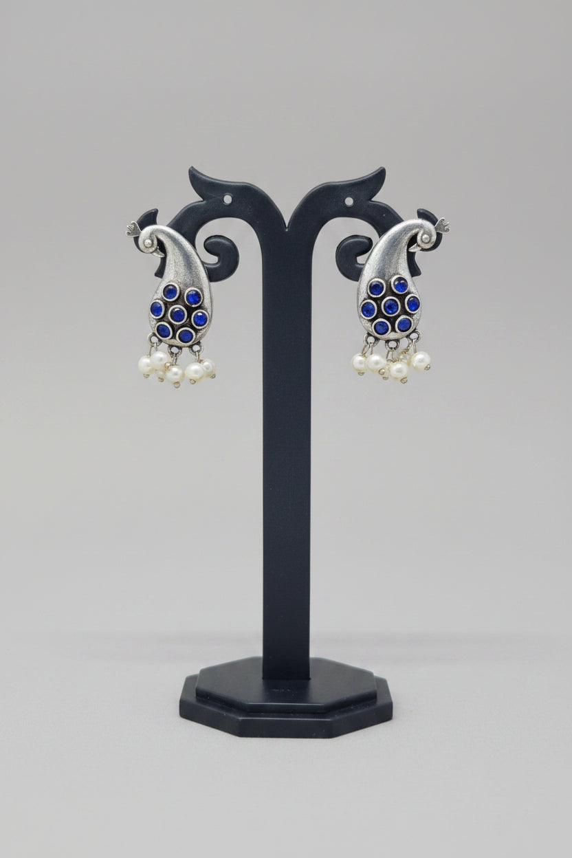 Premium oxidised antique silver peacock hook earrings with navy colored stone accents and pearl drops.