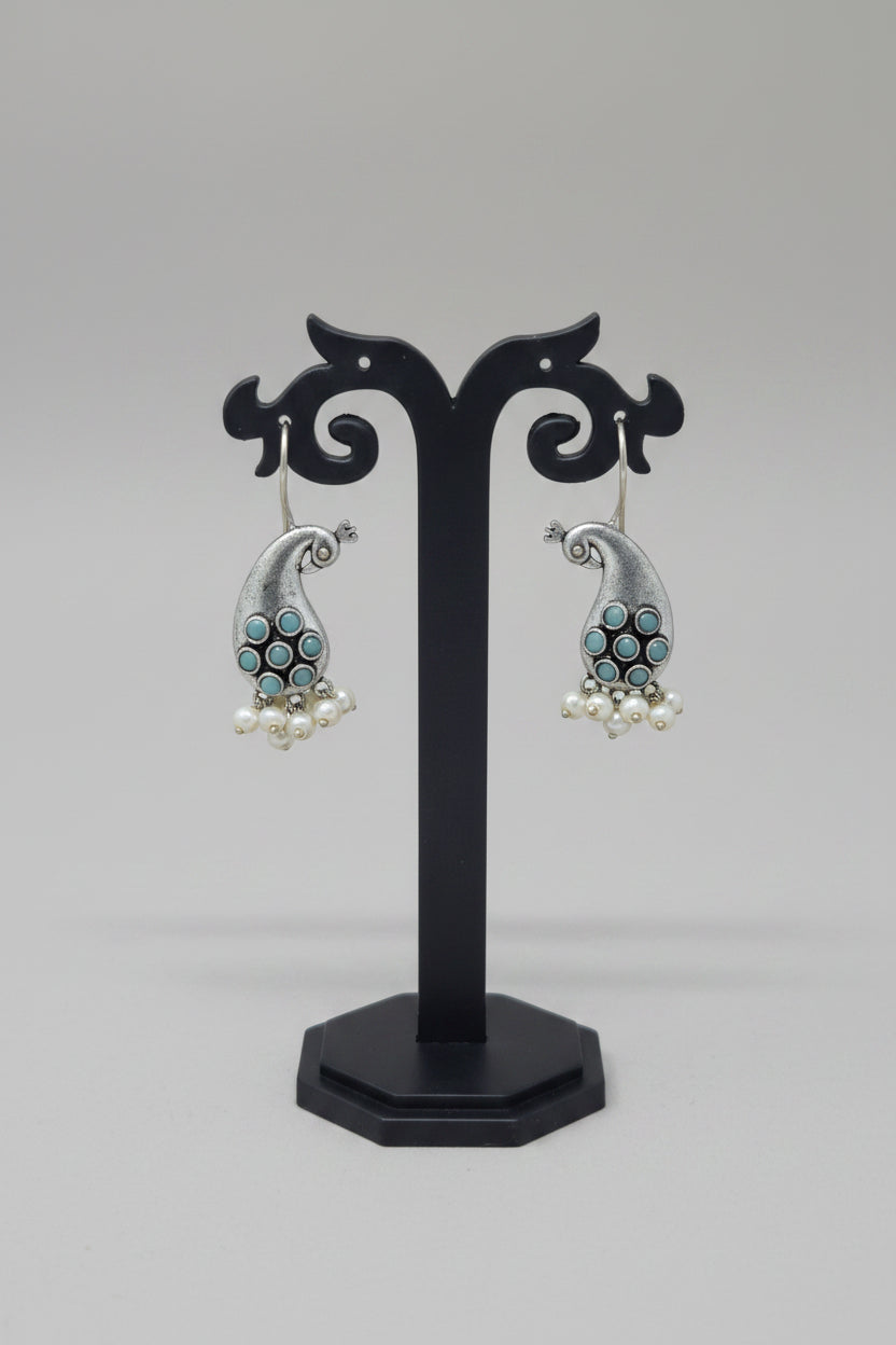 Premium oxidised antique silver peacock hook earrings with turquoise colored stone accents and pearl drops.
