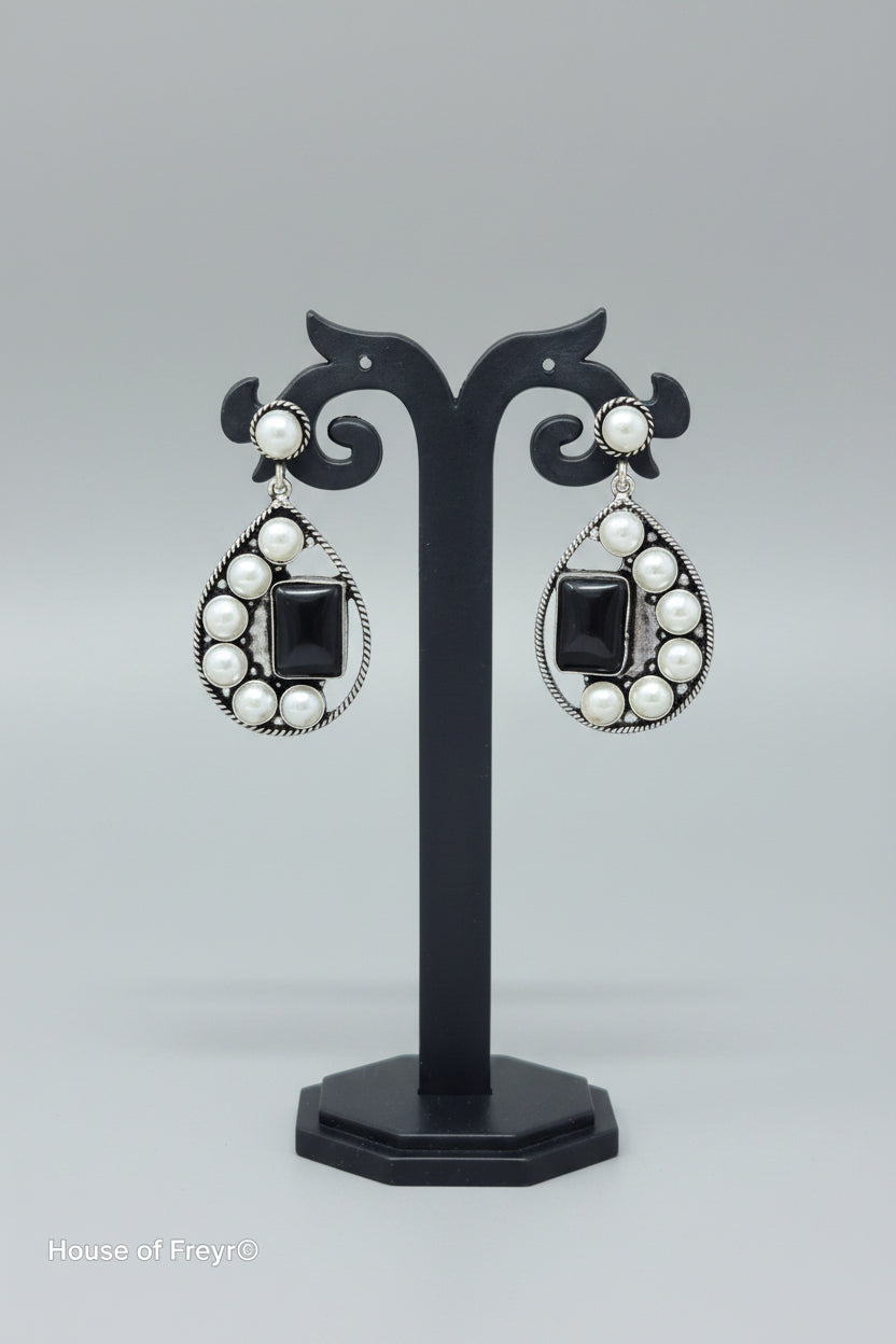 Premium handmade oxidised pearl-embellished teardrop earrings, with a vibrant black gemstone set amidst the pearls.