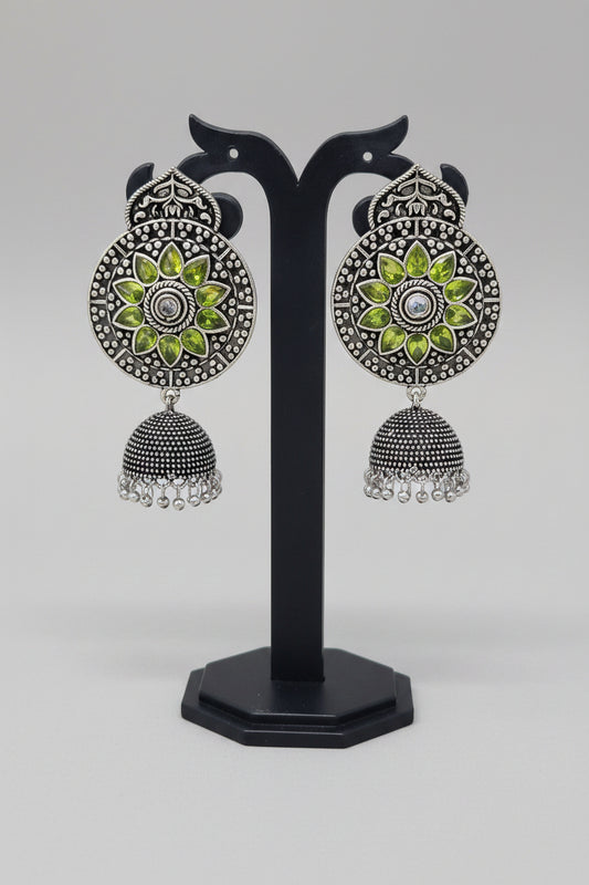 Premium oxidised handmade Ornate earrings with green stones and silver design.