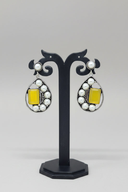 Premium handmade oxidised pearl-embellished teardrop earrings, with a vibrant yellow gemstone set amidst the pearls.