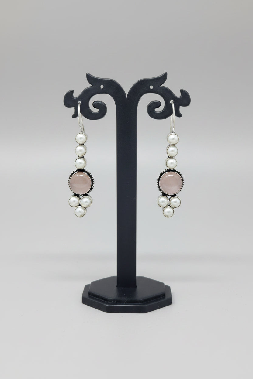 Pair of drop earrings with pink stones and pearls.