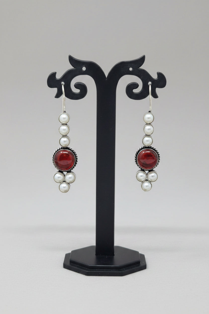 Pair of drop earrings with red stones and pearls.