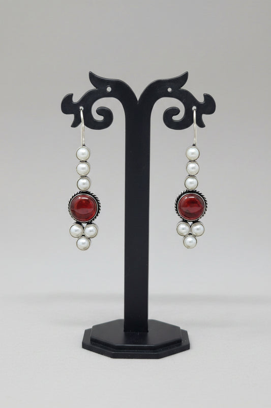Pair of drop earrings with red stones and pearls.
