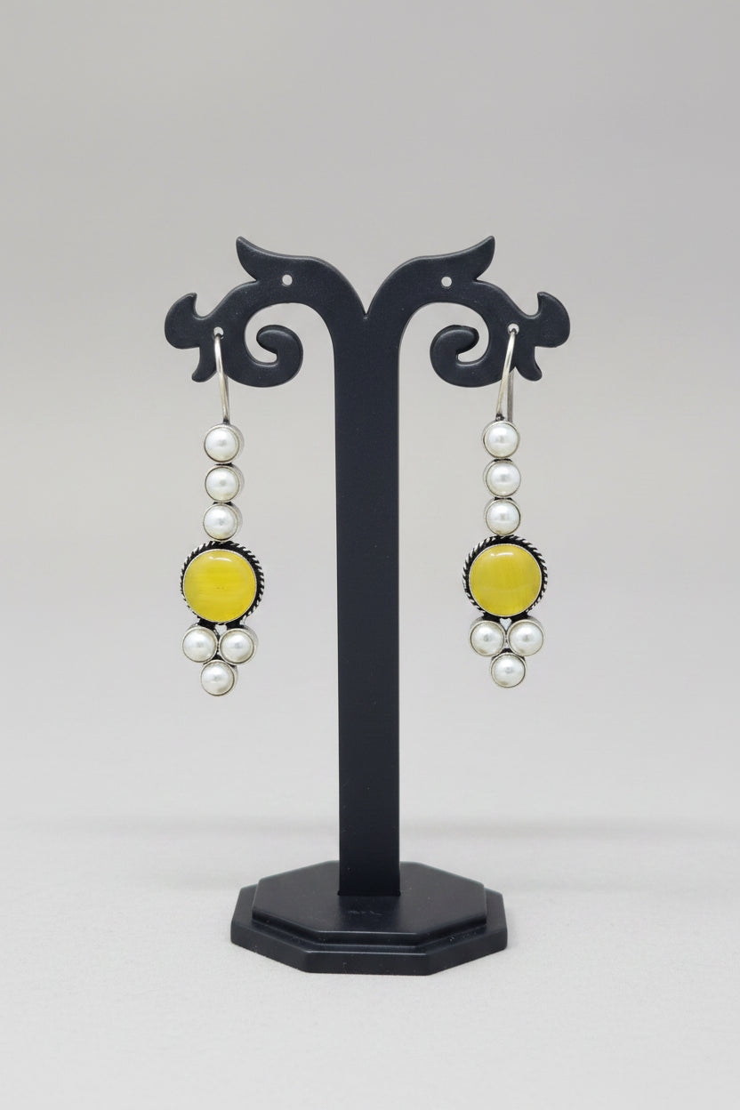 Pair of drop earrings with yellow stones and pearls.