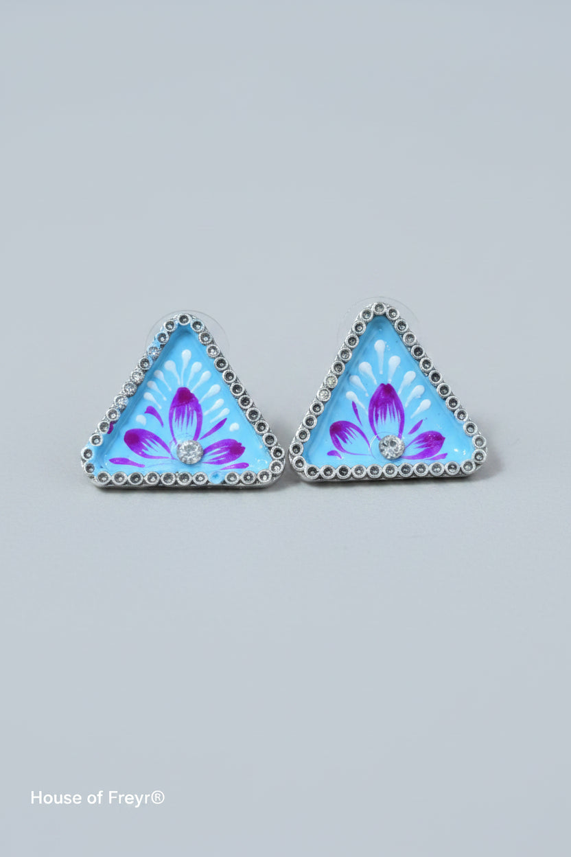Handmade meenakari design, triangular stud earrings with blue floral design on a gray background