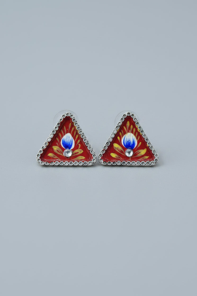 Handmade meenakari design, triangular stud earrings with red and yellow design on a gray background