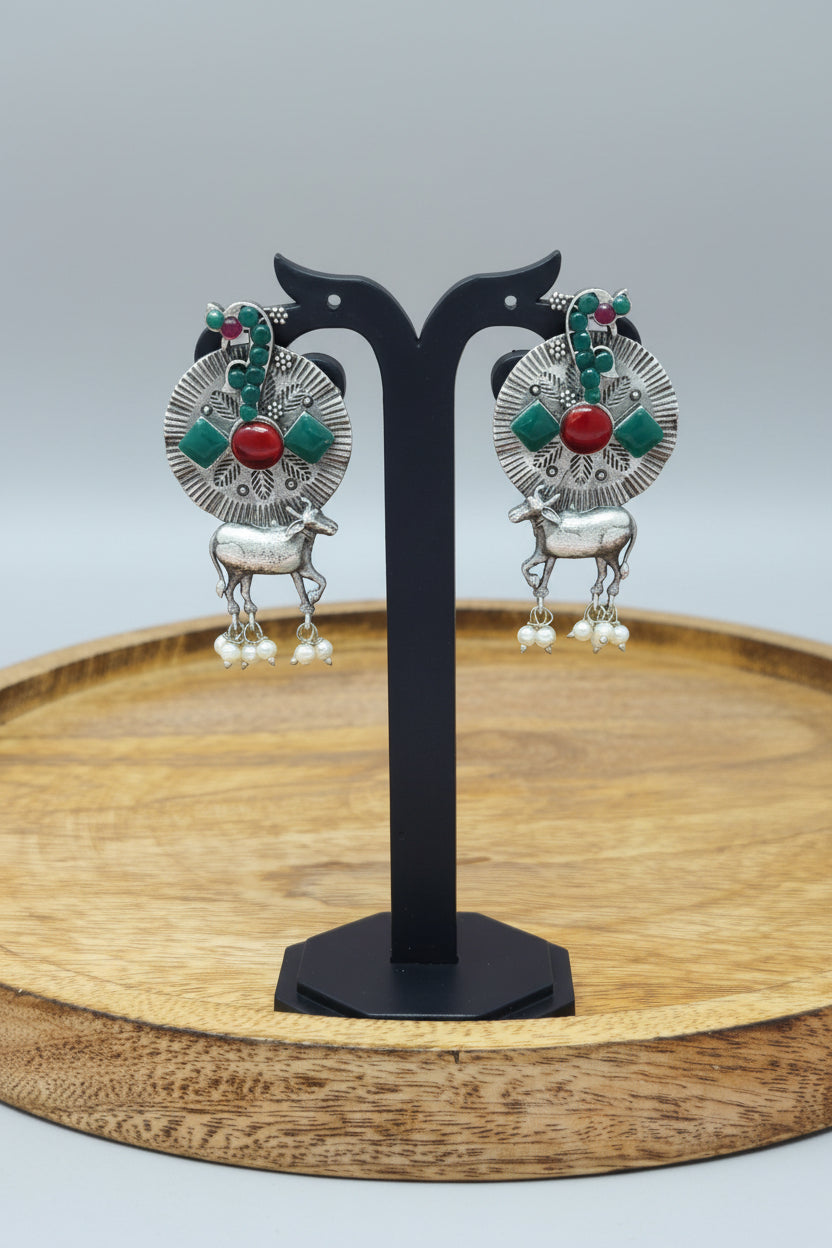 A pair of oxidized silver earrings with a tribal-inspired Nandi design, featuring pastel-colored semi-precious stones and dangling pearls.